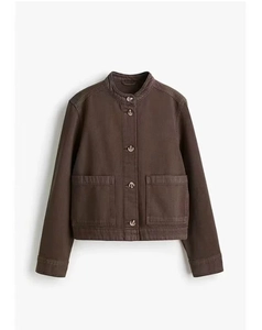 Détails d'une veste en jean marron foncé avec col montant et grandes poches plaquées