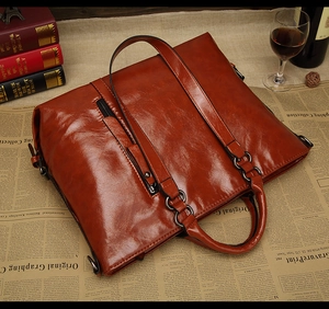 Dettaglio macro della borsa tote in pelle cerata retrò con finitura lucida e zip metallica