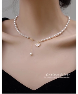 Detailed view of natural pearl necklace featuring heart pendant on elegant gold-plated chain