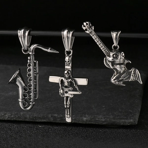 Detailed view of saxophone, skull cross, and skull guitar steel pendants on black stand