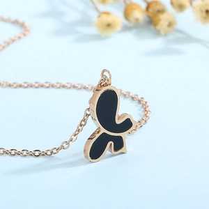 Macro detail of rose gold butterfly pendant with black shell inlay on O-chain necklace