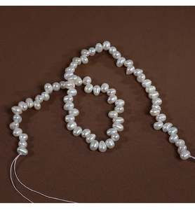 Macro shot of 4-5mm irregular baroque freshwater pearls on dark fabric for jewelry making