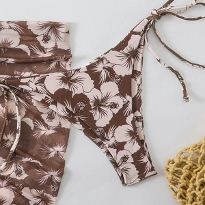 Detail of hibiscus print bikini bottom and matching sarong in brown and beige