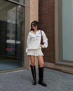 Detail shot of white oversized sweatshirt with embroidered lettering and casual street style