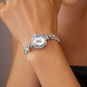 Detail of silver quartz watch featuring a floral rhinestone case and diamond-set bracelet