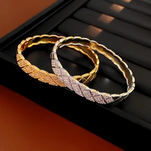 Detailed close-up of gold and silver quilted bracelets with pavé cubic zirconia
