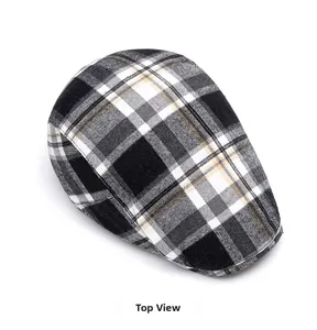 Top down view of a classic plaid newsboy cap in black, white and yellow patterned fabric