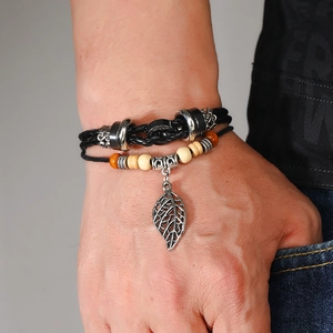 Close-up detail of multi-layer beaded leather bracelet with large leaf pendant