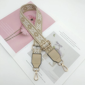 Detail of ethnic geometric woven strap with gold metal hooks and yellow leather ends