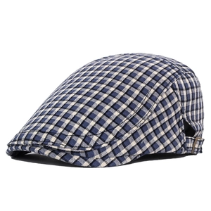 Detail of navy blue plaid flat cap showing the metal buckle and woven texture