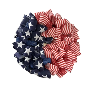 Detailed view of patriotic US flag wreath with red, white and blue star pattern ribbons