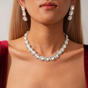 Elegant silver jewelry set with crystal necklace and drop earrings on a model