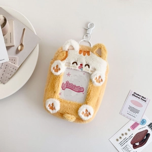 Detailed view of yellow plush cat photo card holder with embroidery and plastic hook