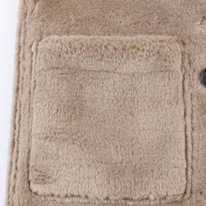 Detailed macro shot of the brown faux fur texture and pocket on this warm winter coat