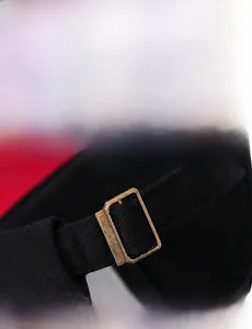Detail view showing precision stitching and bronze adjustable buckle on the black cotton cap