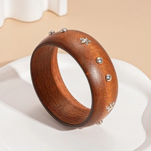 Detail of wide brown wood bangle with silver star studs and metal rivet accents