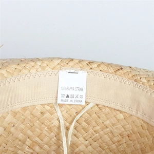 Detail of 100% natural raffia straw hat showing inner lining and material care label