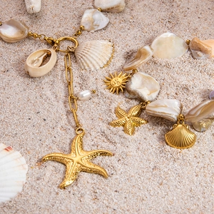 18k gold plated stainless steel necklaces with shell charms on a sandy beach background