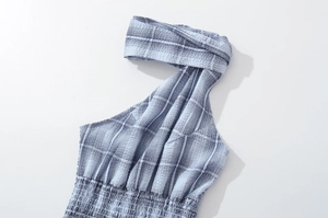 Detailed view of blue and white plaid seersucker fabric with halter neck and elastic waist