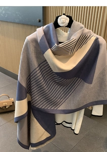 Detail of soft cashmere-feel scarf featuring blue grey beige geometric stripe patterns