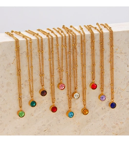 Detailed row of gold birthstone necklaces with colorful gems on a stone display