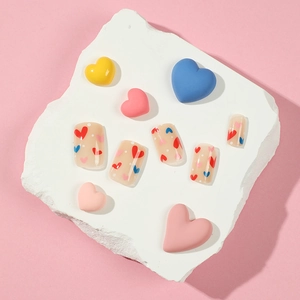 Press on nails with red blue hearts and white dots on a stylish display stone