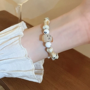 Close-up of minimalist beaded puppy bracelet with bone charms on a female wrist
