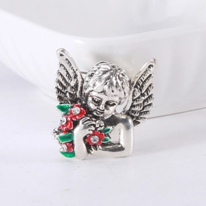 Macro shot of silver angel brooch with colorful enamel flowers and shimmering rhinestones