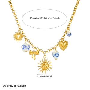 Gold necklace with sun, ceramic heart and bow pendants on a minimalist white background