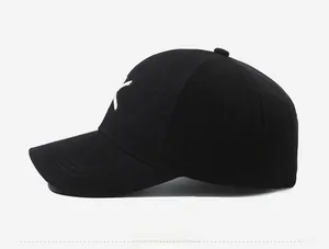 Detail view of black cotton baseball cap showing white letter embroidery and side stitching
