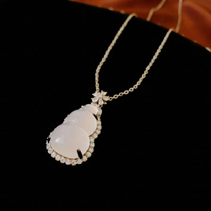 Macro shot of white resin gourd pendant necklace with sparkling zircon pavé setting