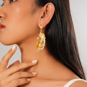 Detail of vintage gold horse head earrings with rhinestones worn by a fashion model