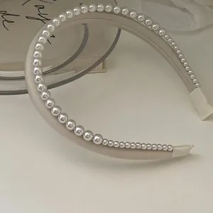 Elegant satin double-layered headband with gradient pearls on a minimalist ivory base