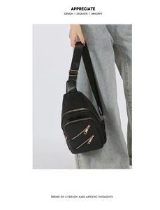 Close-up of black PU leather chest bag with gold zippers and litchi texture finish