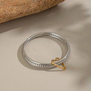 Silver multi-layer circle bracelet with gold heart charm and beaded texture