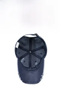 Détail d'une casquette baseball en jean bleu délavé avec bord usé et boucle de serrage