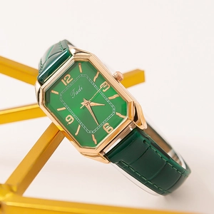 Detail of vintage octagonal green dial watch with gold case and crocodile leather strap