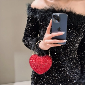Detailed view of luxury heart-shaped evening bag with red rhinestones and gold chain