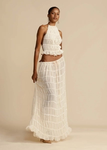 Detail view of cream halter neck top and pleated maxi skirt with ruffled textures