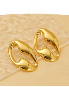 Macro detail of gold irregular hollow oval earrings made of polished titanium steel