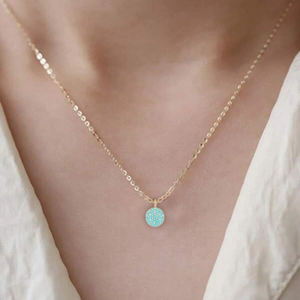 Close-up of gold S925 silver necklace with turquoise moon pendant worn by model