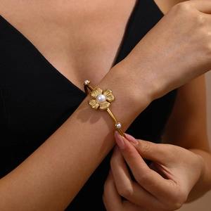 Adjustable golden flower cuff bracelet with white pearls and textured metal petals