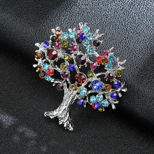 Macro shot of silver-plated tree of life brooch with vibrant colorful crystals on leather
