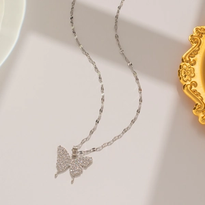 Detailed view of silver bow necklace with sparkling zircon butterfly pendant in studio light
