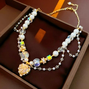 Close-up of heart crown pendant with pearls and crystals in a luxury brown display box