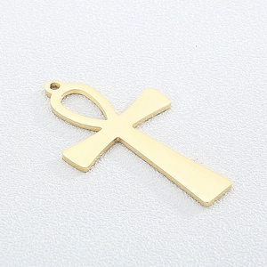 Polished gold titanium steel Ankh cross pendant necklace charm on a textured surface