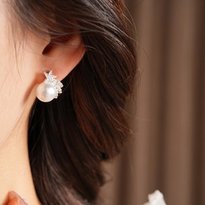 Gros plan de boucles d'oreilles perles avec étoile en zircon portées par un mannequin