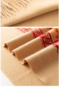 Vue détaillée de l'écharpe en cachemire beige avec broderie florale rouge et franges douces