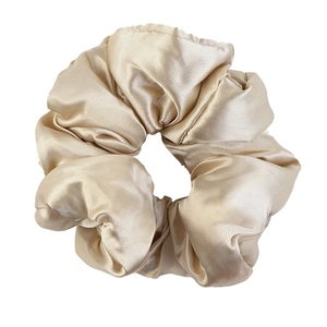 Champagne satin silk oversized scrunchie hair tie with elegant pleated fabric and glossy finish