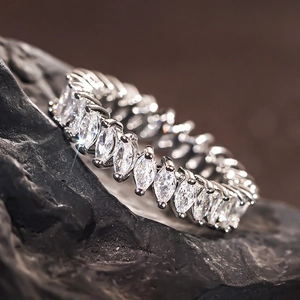 Elegant marquise-cut eternity ring in silver finish displayed on black rock texture